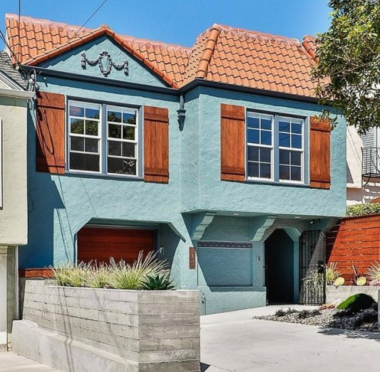 A Teal Colored Stucco House With Stained Wood Accents A Teal Colored Stucco House With Stained Wood Accents